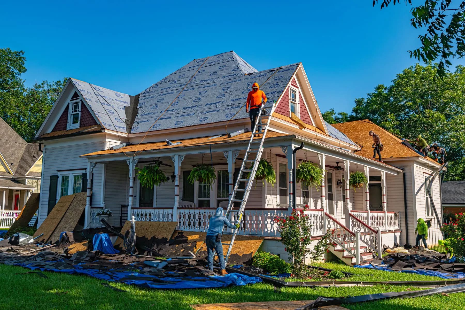 Roofing crew installing underlayment on a historic home